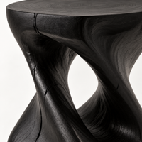 Black sculptural side table on an outdoor patio