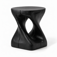 Black twisted accent table used as a nightstand